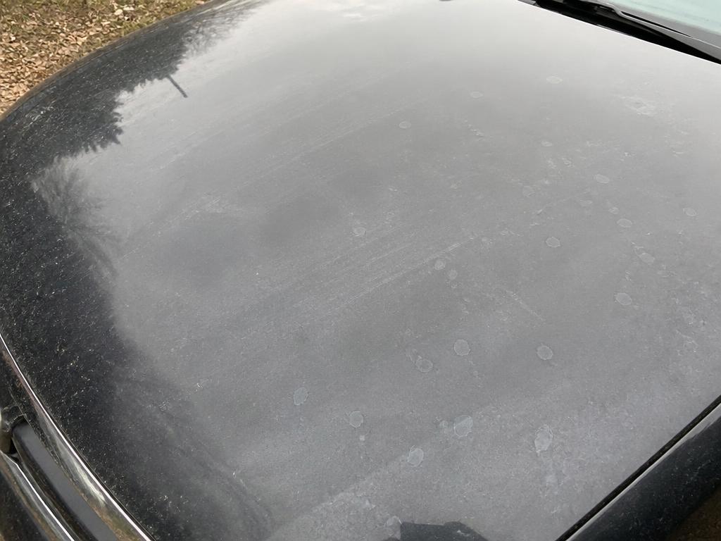 Dull car hood covered in road grime, dust and water spots